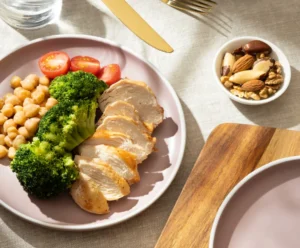 Prato com proteínas magras e vegetais, essencial na alimentação pós-cirurgia plástica para cicatrização.