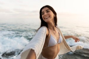 Mulher confiante a bera mar após um cirurgia plástica