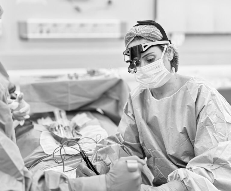 Médico revisando laudos de exames e realizando avaliação clínica da paciente no consultório para garantir a segurança da cirurgia de mama.