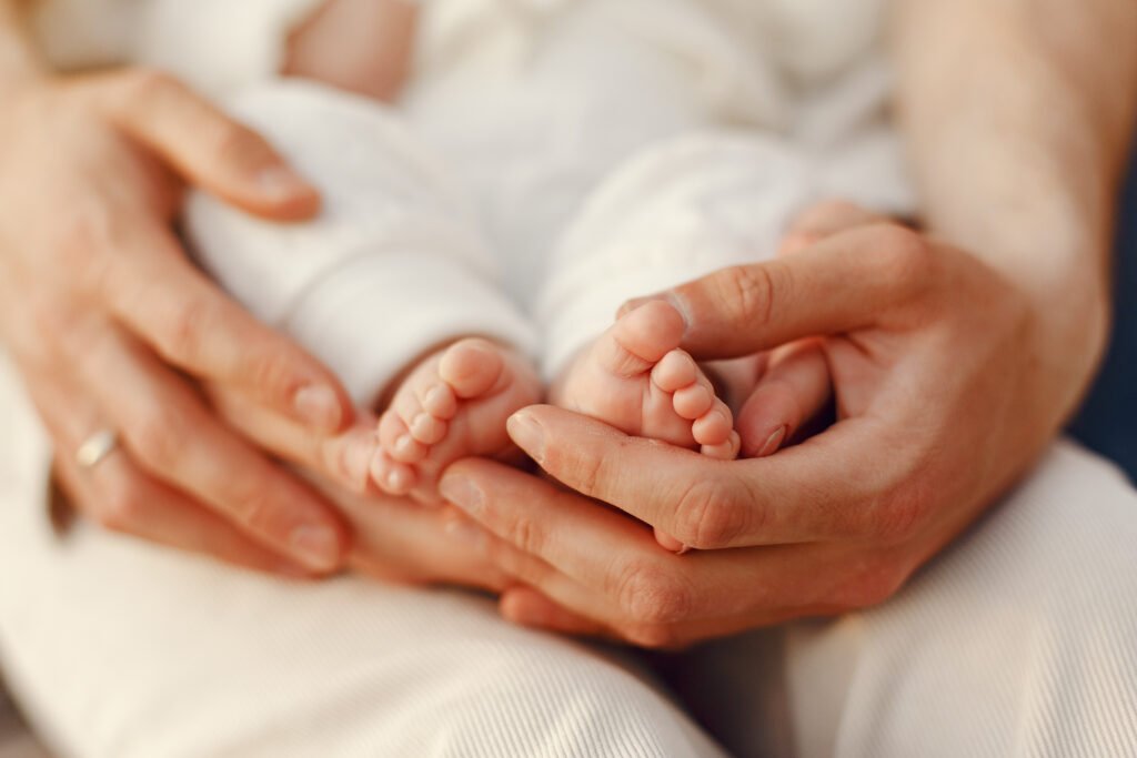 Mãe segurando os pês do filho recém-nascido com afeto